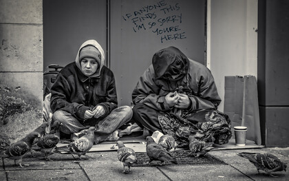 Homelessness and poverty manifesting in men begging on the streets of the UK, highlighting the urgent social issue of unemployment and its impact on lives
