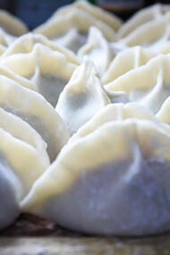 Uzbek food specialty: manti dumplings filled with spiced meat and served with a dollop of yogurt