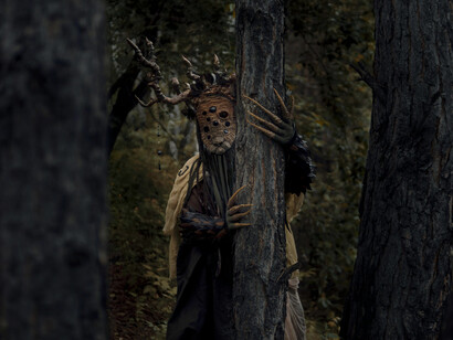 Mysterious figure emerging among trees at night, symbolizing the human tendency to project meaning onto the unknown