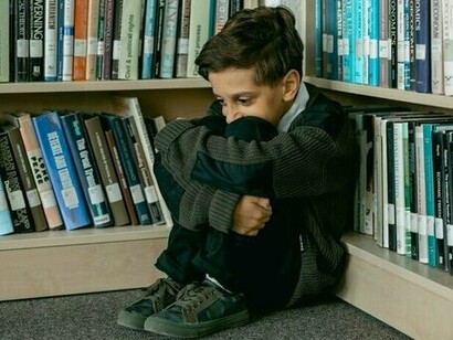 A child crying in a corner, representing how some wounds cut deeper and leave lasting scars that may never fully heal