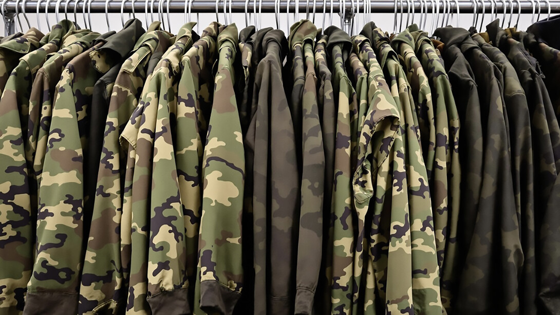 Military uniforms hanging on clothing rack