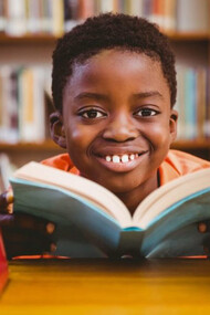 Niño disfrutando la lectura en una biblioteca