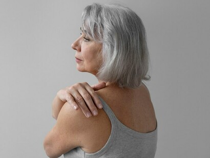 An older woman with joint pain, captured in a thoughtful and composed posture