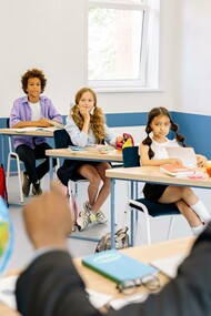 Teacher points to the globe in the classroom
