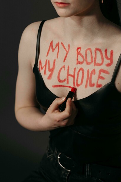 A close up of red lettering “my body..” scrawled across skin reminds us that ownership of one’s body remains contested terrain 