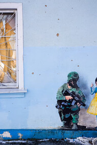Grafiti en que una niña vestida con los colores de la bandera de Ucrania confronta a un soldado ruso