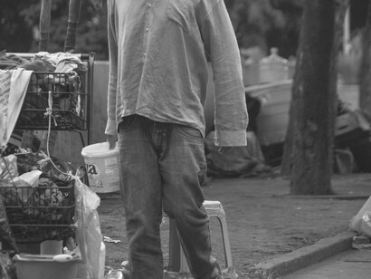 Homem em situação de rua em São Paulo, Brasil. São vielas sujas, com todo tipo de água correndo a céu aberto, desde o da limpeza da "casa" aos esgotos adaptados...