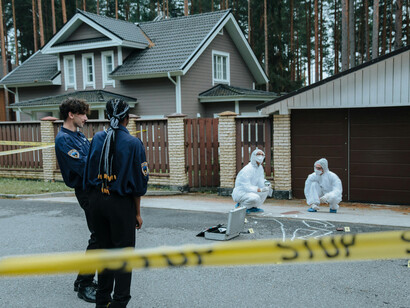 Forensic investigators examining and discussing evidence at a crime scene
