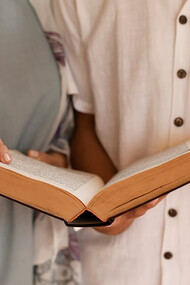 Front view of people from Christian and Muslim faiths praying together in unity