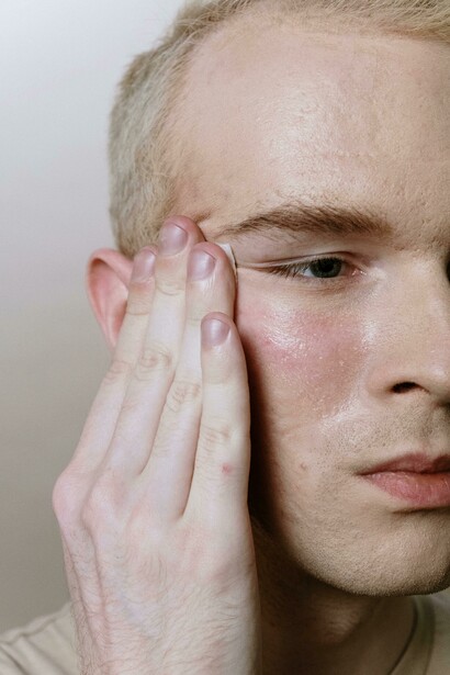 A man applying his skincare routine with fall creams and serums