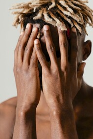 Homem encobre o rosto com vergonha