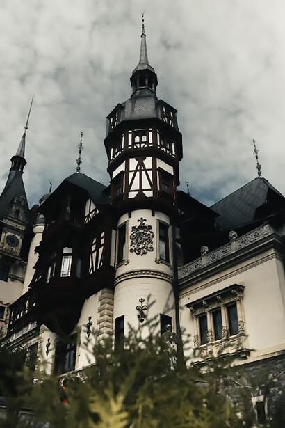 An imposing Romanian castle with a prominent clock tower and a spooky atmosphere