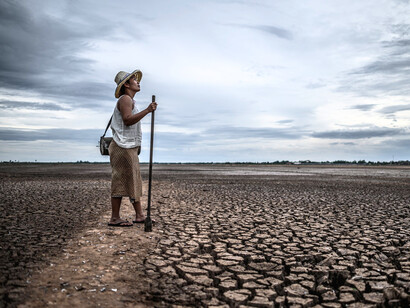 A man walking on broken earth, symbolising the consequences of shrinking natural resources