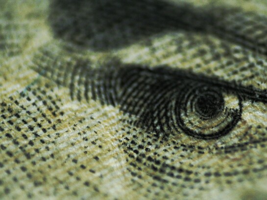 Primo piano dell'occhio su una banconota: la valuta dello Stato come strumento di sorveglianza e controllo del comportamento dei cittadini