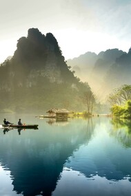 A boat carrying two people glides through the waters of Tuyên Quang City, Vietnam
