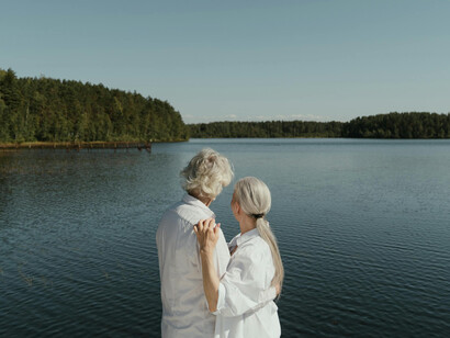 A happy, mature couple hugging by the lake, enjoying a peaceful moment together.
