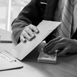 A businessman receiving a brown envelope filled with money, depicting bribery and unethical dealings in the office