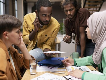 A multicultural group working together, reflecting how Moroccan–American exchanges thrive on shared learning, collaboration, and cross-cultural respect