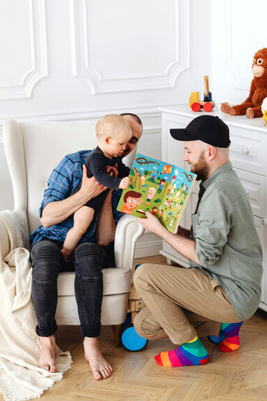 A joyful gay couple playing with their child, symbolizing love, family, and queer creativity