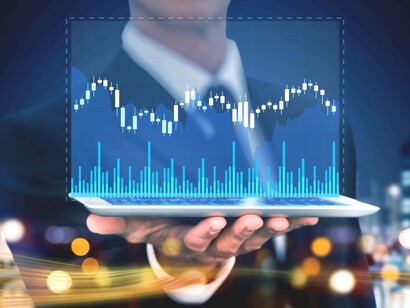 Un uomo d’affari tiene in mano un tablet da cui emerge un grafico azionario digitale con candele e volumi. L’immagine rappresenta l’analisi finanziaria in tempo reale e la tecnologia nel mondo degli investimenti