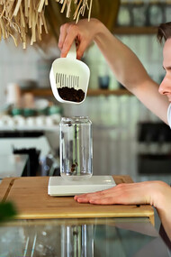 A barista preparing a beverage and brewing coffee with precision