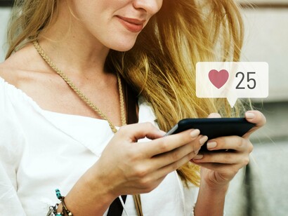 A woman smiling at the notifications, showing how fully immersed she is in the digital world 
