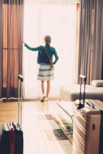 A lone female tourist steps into her hotel room