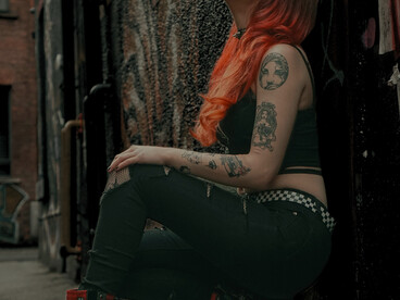 Rebellious youth fashion: a tattooed woman with dyed hair in a crop top