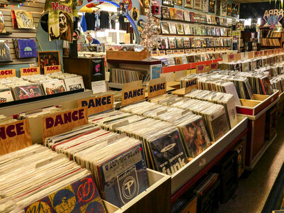 A vintage vinyl record store alongside a small record label workspace