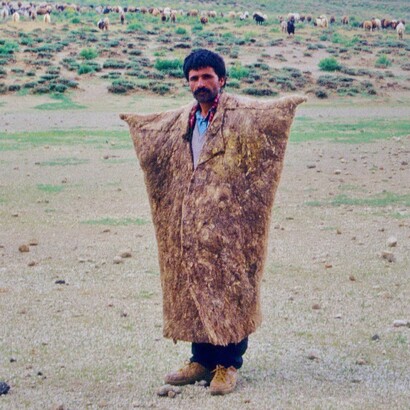L'immagine ritrae un pastore nomade con il suo gregge presso il lago prosciugato Göper Göl, nella caldera del Nemrut Dağı, mentre indossa il suo speciale «cappotto invernale» per proteggersi dal freddo che spesso regna in alta quota. Foto di Volker Höhfeld