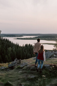 As the sun sets in the distance, a couple embraces the warmth of happiness that fills their hearts and minds, reminding them of the essential role serotonin plays in their well-being