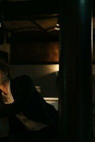 Giovane seduto al tavolo di un bar osserva con curiosità