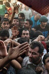 Syrian refugees fight for clothes and other items being distributed by Kurdish people at the Kawrkos camp outside of Erbil, in Northern Iraq, August 20, 2013 captured by Lynsey Addario 