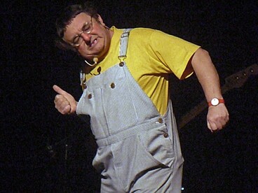 Henri Giraud imita Coluche de macacão na primeira parte de seu espetáculo Tchao l'enfoiré, 2010. Coluche jamais ensejou ares providenciais como o general De Gaulle. Mas diante da crise atual francesa ele representa alguma esperança. Ou, ao menos, alguma razão para voltar-se a sorrir