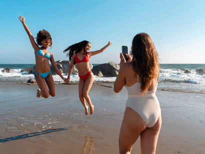 Young women enjoying themselves at the beach in bikinis