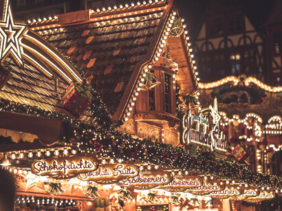 Stalls glowing under the cold night skies in a German market, mirroring the small comforts found amid unfamiliar roads