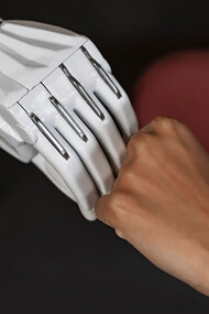 A woman and a robot joining hands 