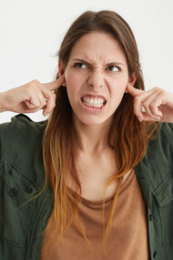 Mulher tapando os ouvidos. A  Maria não gosta de ouvir música