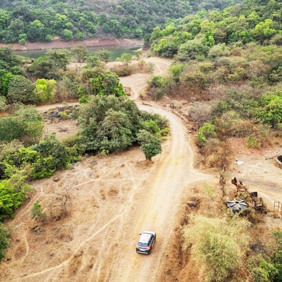 A brown Maruti Brezza explores the dirt roads of the Khandala Countryside, Lonavala, India; Lonavala is the "Monsoon Gateway" because of the stunning waterfalls that emerge from the slopes of the mountains 


