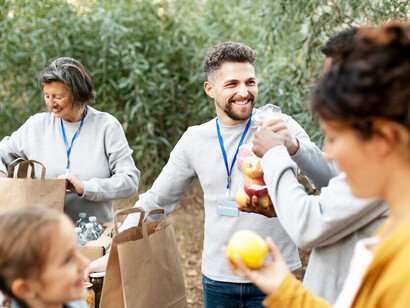Volunteers gathering food donations, extending helping hands, and strengthening human connection through acts of kindness and support