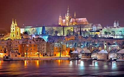 The Prague Castle District beautifully illuminates at night, casting a magical glow over the city