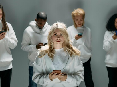 A group of individuals engrossed in their phones, conveying how modern life blurs attention and awareness