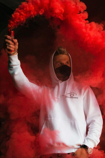 In Tallinn, Harju County, Estonia, a man in a hoodie and mask holds a smoke bomb