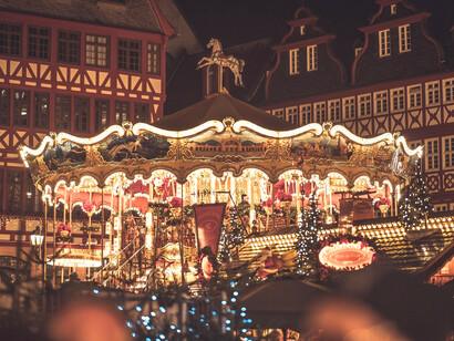 A bustling German night market with twinkling lights and a carousel, reminding that even in loneliness, beauty can still find you