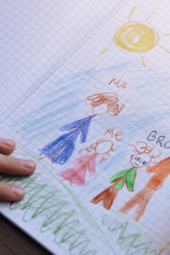 Lápis de colorir desliza pelo papel para criar desenho de uma família