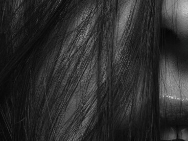 A portrait of a beautiful woman with black hair, capturing her feminine and sexy elegance