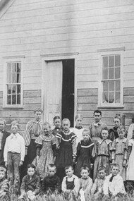 The Little Red School House in California, USA from long ago, with women as the teachers of different ages of children