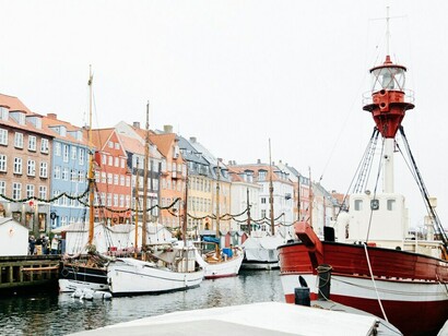 In Copenhagen, Denmark, colorful boats float along the canals, framed by the city's stunning old architecture