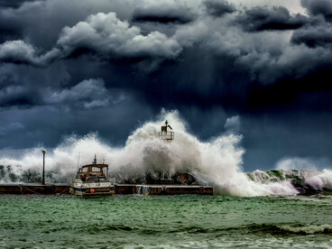 Powerful waves under a dark, cloudy sky, representing a post-earthquake tsunami