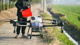 Individual refilling a big agricultural drone for farming use